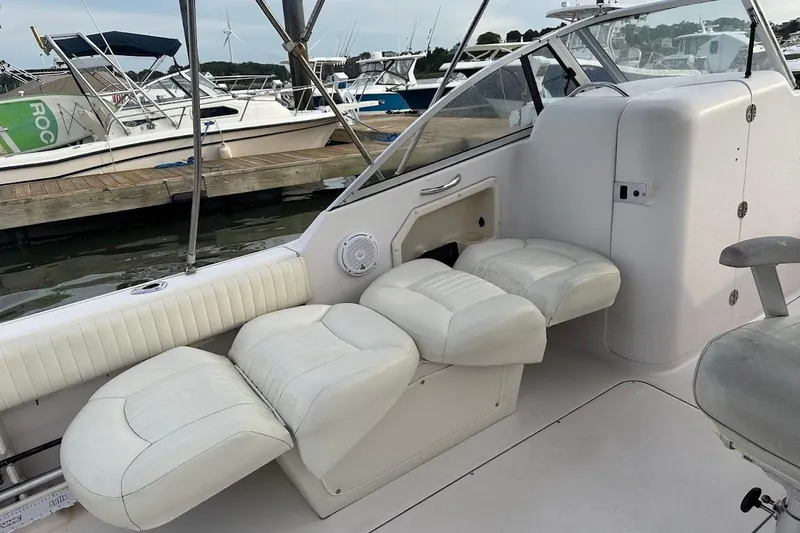 Slide: The Image of 2004 Grady-White Tournament 225 boat interior with white seating at marina. - 16