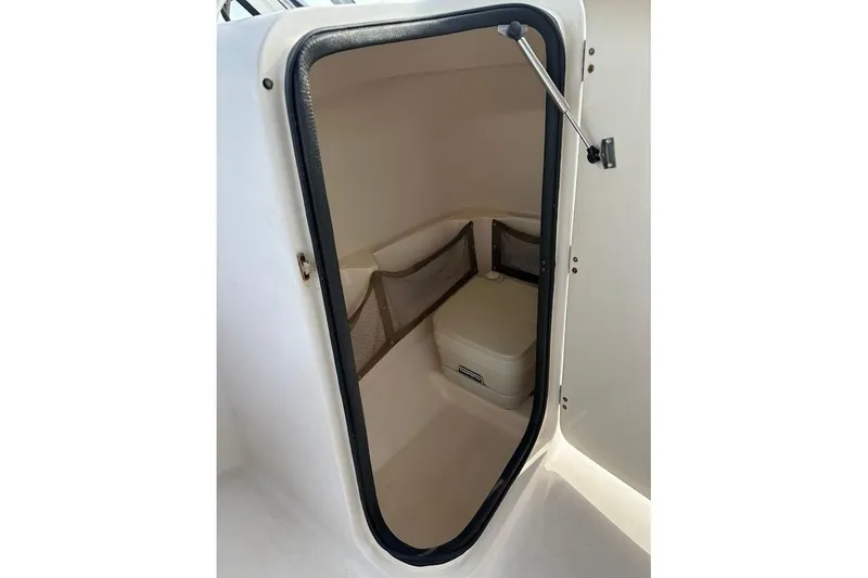 Slide: The Image of 2004 Grady-White Tournament 225 boat interior storage compartment with netting and cooler. - 17