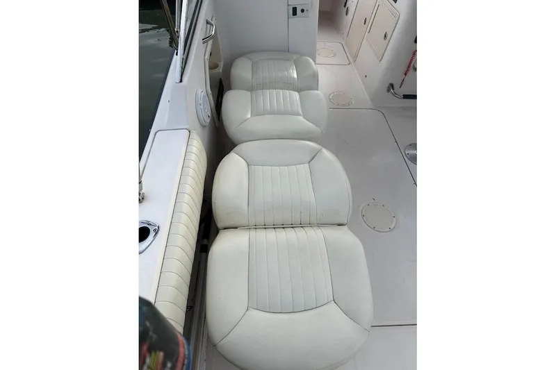 Slide: The Image of White cushioned seats on a 2004 Grady-White Tournament 225 boat interior. - 24