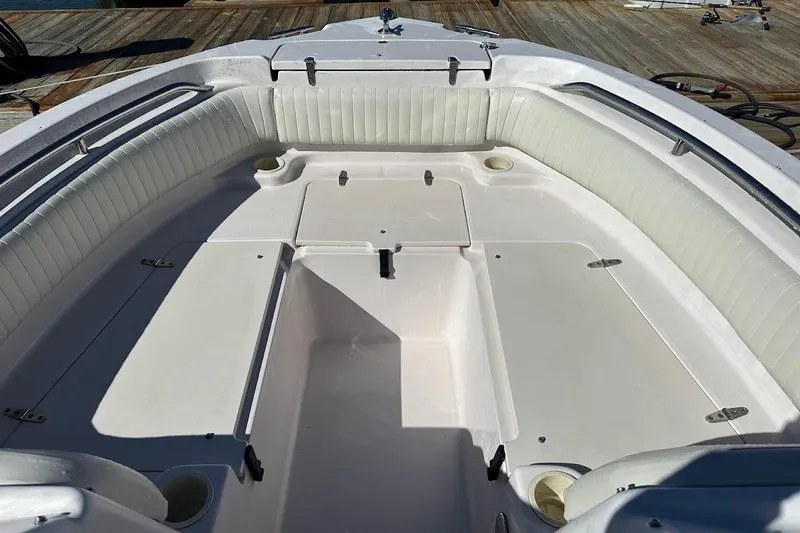 Slide: The Image of 2004 Grady-White Tournament 225 boat interior with white seating and storage compartments. - 9