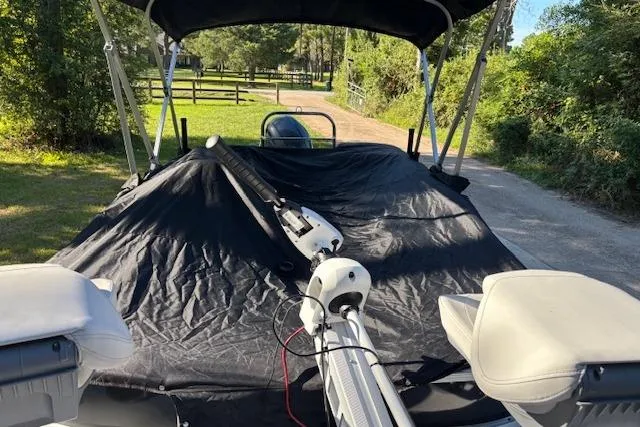 Slide: The Image of 2025 Hurricane FunDeck 198 RE OB boat with cover, parked on a sunny day. - 10