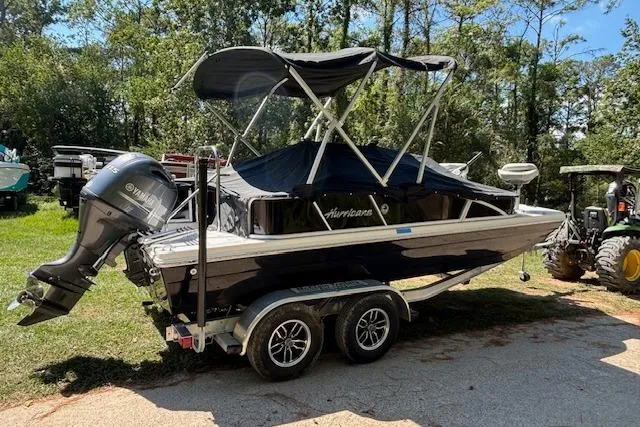 Slide: The Image of 2025 Hurricane FunDeck 198 RE OB boat on trailer, parked outdoors with canopy. - 3