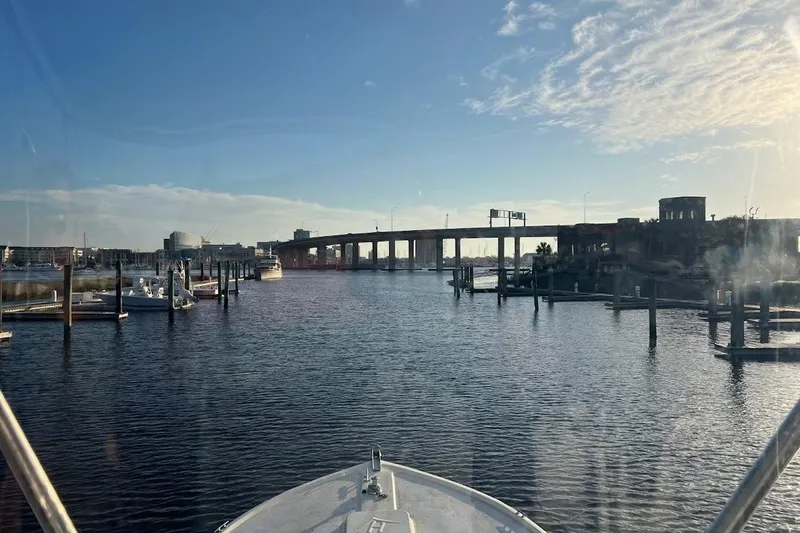 Slide: The Image of 1963 Hatteras 34 Convertible navigating marina with bridge and clear sky. - 13