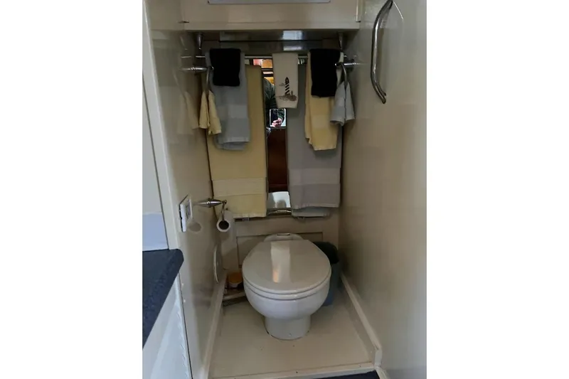 Slide: The Image of Compact bathroom in a 1963 Hatteras 34 Convertible yacht, featuring a toilet and towel rack. - 30