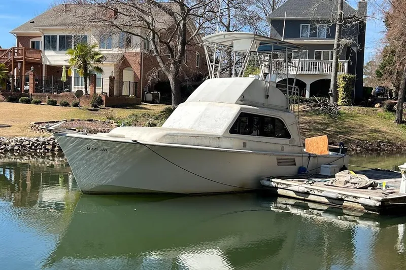 Slide: The Image of 1963 Hatteras 34 Convertible boat docked by waterfront homes. - 40
