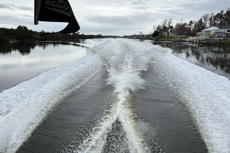 Slide: The Image of Wake trail from a 1963 Hatteras 34 Convertible boat on a calm river. - 18