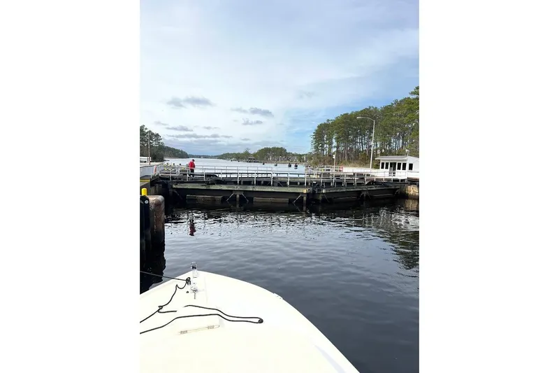 Slide: The Image of 1963 Hatteras 34 Convertible approaching a lock on a calm waterway. - 23