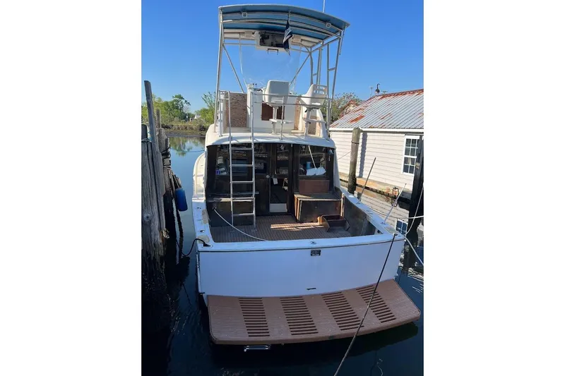 Slide: The Image of 1963 Hatteras 34 Convertible boat docked, rear view with ladder and deck. - 24