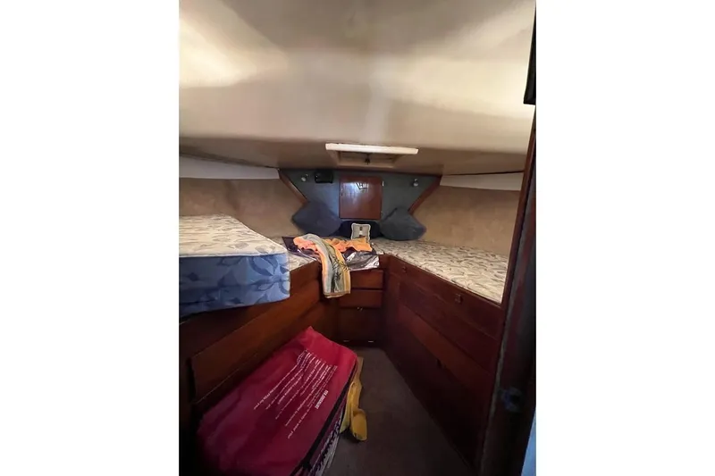 Slide: The Image of 1963 Hatteras 34 Convertible cabin interior with twin beds and wooden storage. - 31