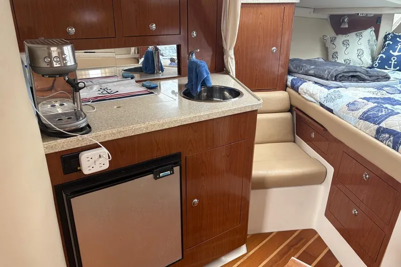 Slide: The Image of 2010 Regal 3360 Window Express interior with kitchenette and cozy sleeping area. - 11