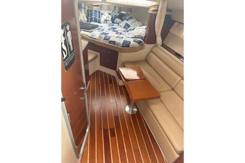 Slide: The Image of 2010 Regal 3360 Window Express cabin with wood flooring, beige seating, and a cozy bed area. - 13