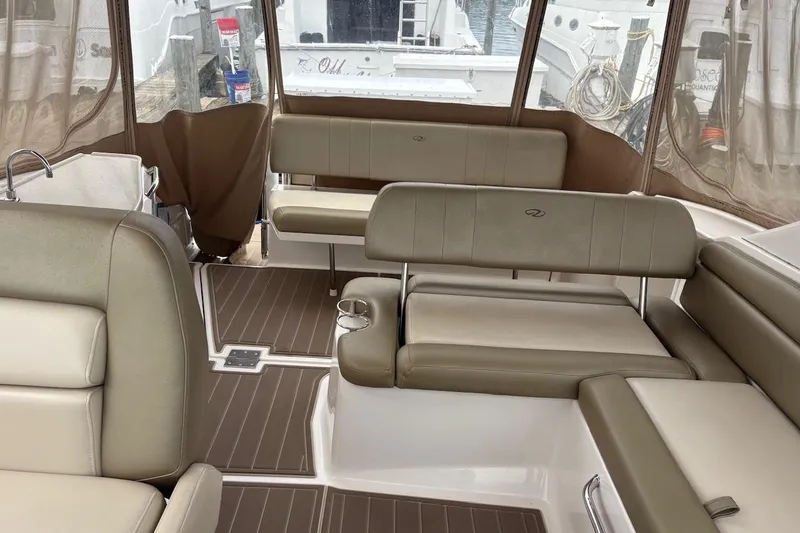Slide: The Image of Interior of 2010 Regal 3360 Window Express boat with beige seating and wood flooring. - 8