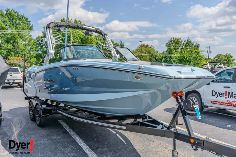 Slide: The Image of 2026 MasterCraft NXT24 boat on trailer in parking lot, sunny day. - 6