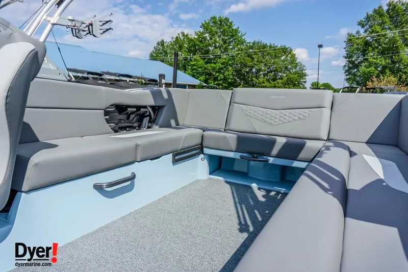 Slide: The Image of 2026 MasterCraft NXT24 boat interior with gray seating and blue accents under a clear sky. - 9