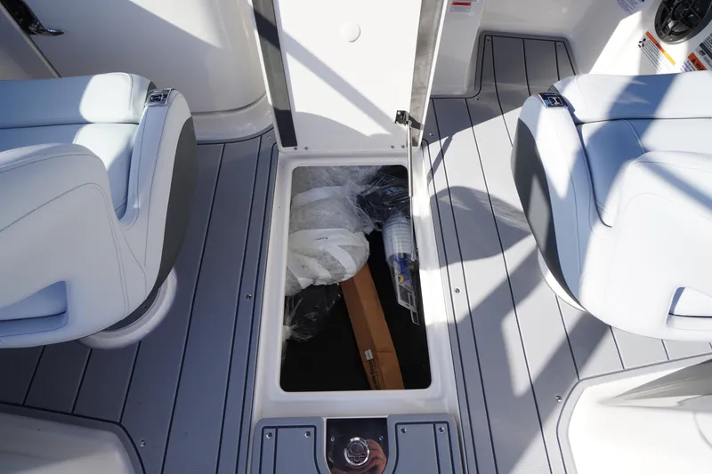 Slide: The Image of 2026 Chaparral 250 OSX boat interior storage compartment with seating and accessories. - 31