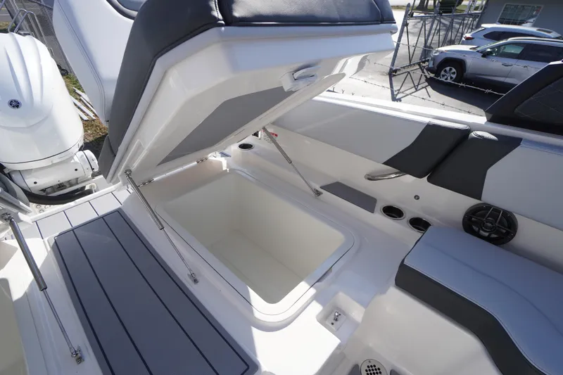 Slide: The Image of 2026 Chaparral 250 OSX boat interior with open storage compartment and seating. - 43