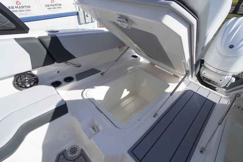 Slide: The Image of 2026 Chaparral 250 OSX boat interior storage compartment with open hatch. - 44