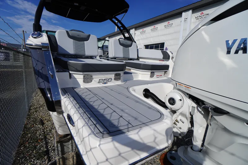 Slide: The Image of 2026 Chaparral 250 OSX boat with Yamaha engine, docked near a fence under clear skies. - 52
