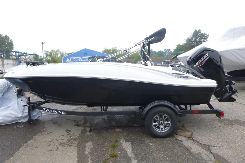 Slide: The Image of 2026 Tahoe T16 boat on trailer with Mercury outboard motor, parked outdoors. - 3