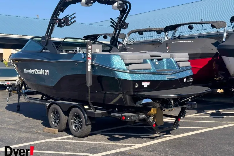 Slide: The Image of 2026 MasterCraft XT22 T boat on trailer, parked in marina lot. - 1