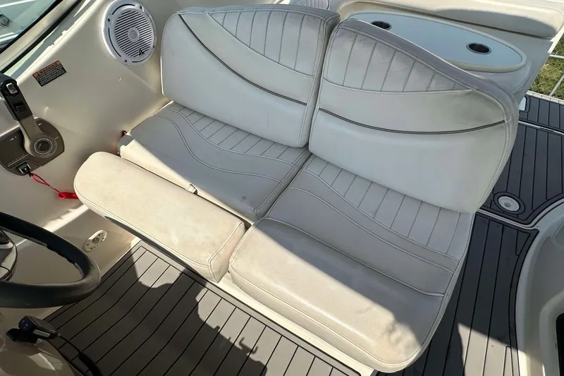 Slide: The Image of White leather seating on 2000 Maxum 2700 SCR boat, featuring cup holders and control panel. - 3