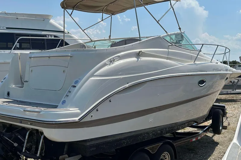 Slide: The Image of 2000 Maxum 2700 SCR boat on trailer, white exterior, under sunny sky. - 6