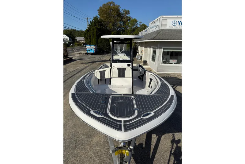 Slide: The Image of 2023 Tidewater 232 SS boat with sleek design, parked outside dealership. - 10