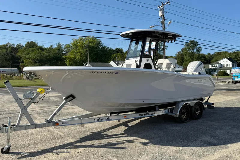 Slide: The Image of 2023 Tidewater 232 SS boat on trailer, parked outdoors, clear sky background. - 3