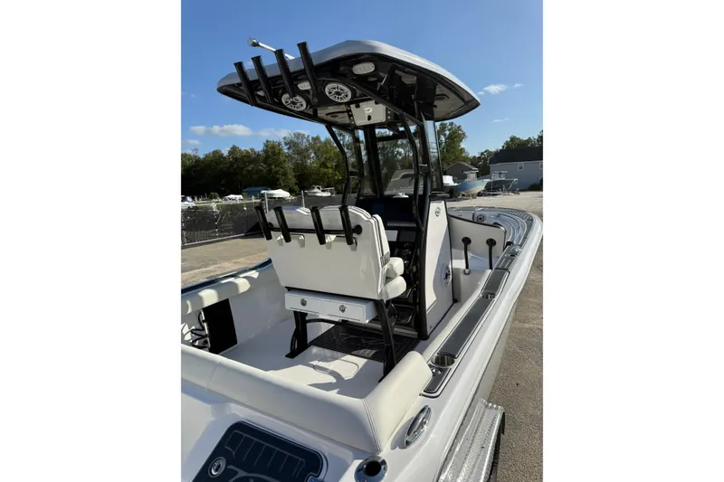 Slide: The Image of 2023 Tidewater 232 SS boat with T-top and seating, docked outdoors. - 6
