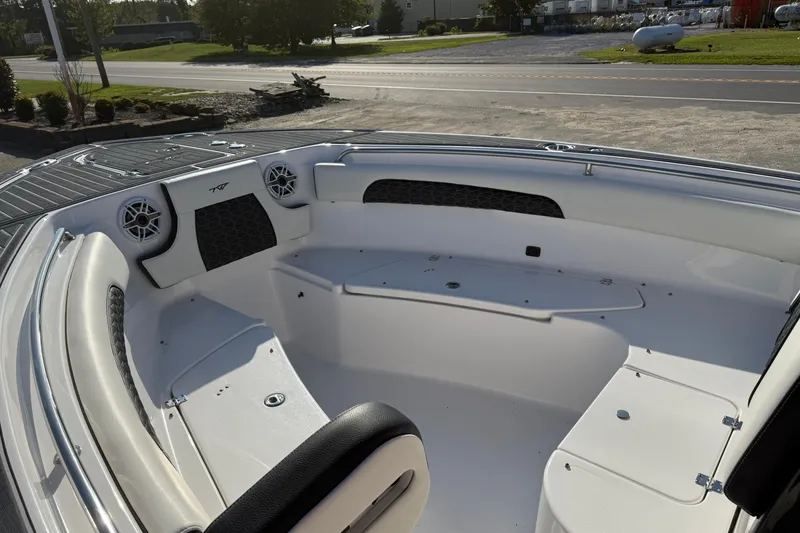 Slide: The Image of 2023 Tidewater 232 SS boat interior with seating and speakers, parked outdoors. - 8