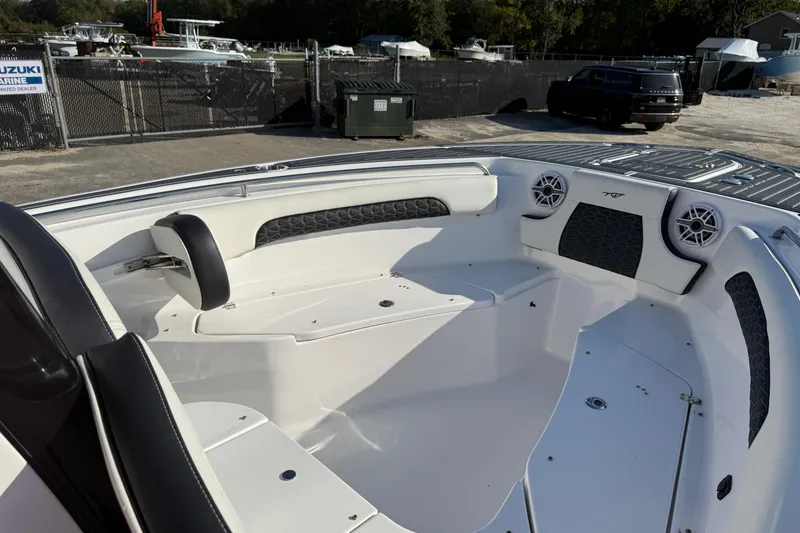 Slide: The Image of 2023 Tidewater 232 SS boat interior with seating and speakers, parked at a marina. - 9