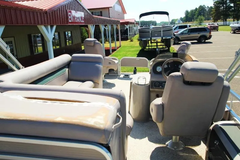 Slide: The Image of 2008 Premier 221 Cast-A-Way boat interior with seating and steering wheel, parked near entrance. - 11