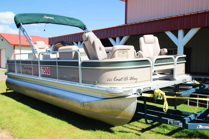 Slide: The Image of 2008 Premier 221 Cast-A-Way pontoon boat on trailer, parked near a building. - 12