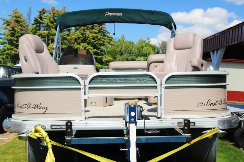 Slide: The Image of 2008 Premier 221 Cast-A-Way pontoon boat on trailer, beige seating, green canopy, outdoor setting. - 2