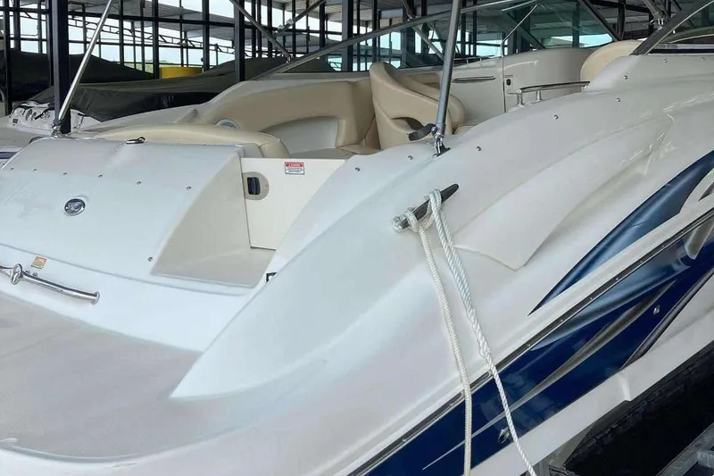 Slide: The Image of 2002 Sea Ray 270 Sundeck boat in a marina, showcasing sleek design and spacious seating. - 15