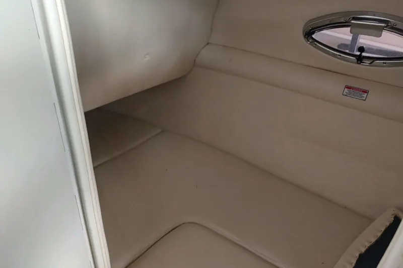 Slide: The Image of Interior cabin of 2002 Sea Ray 270 Sundeck with beige upholstery and porthole window. - 16