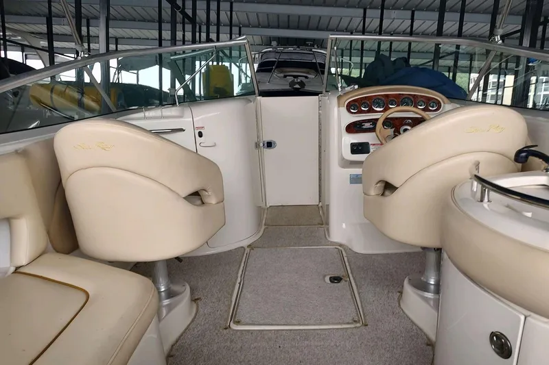 Slide: The Image of Interior of a 2002 Sea Ray 270 Sundeck boat with beige seating and dashboard. - 19