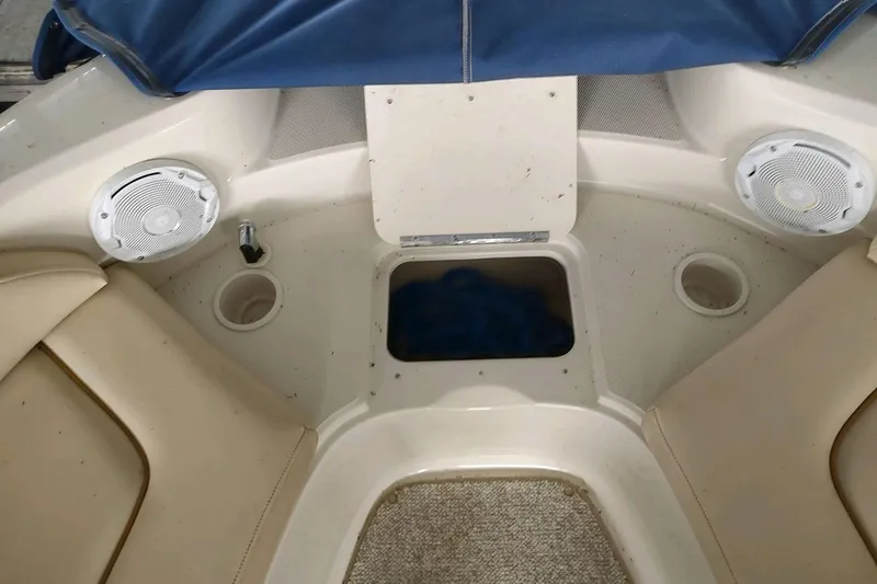 Slide: The Image of 2002 Sea Ray 270 Sundeck interior with beige seating and built-in speakers. - 25