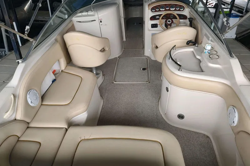 Slide: The Image of Interior of a 2002 Sea Ray 270 Sundeck boat with beige seating and dashboard. - 3