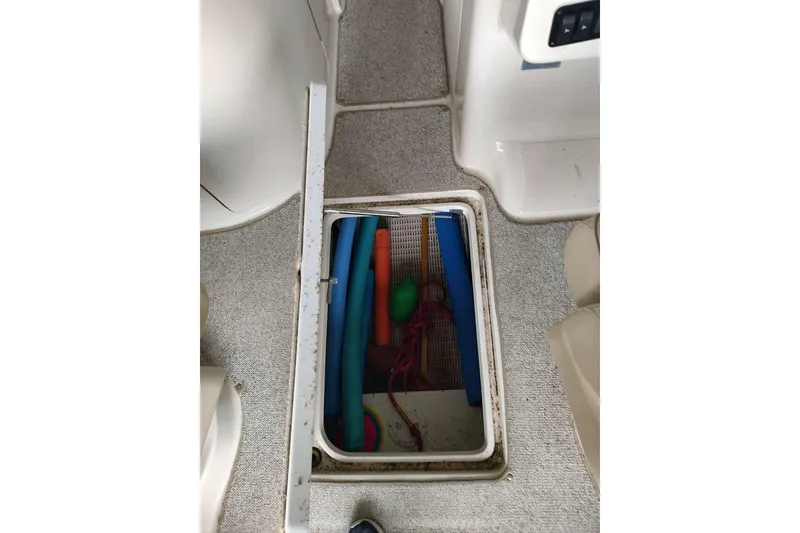 Slide: The Image of Open storage compartment on 2002 Sea Ray 270 Sundeck boat, containing colorful pool noodles. - 5