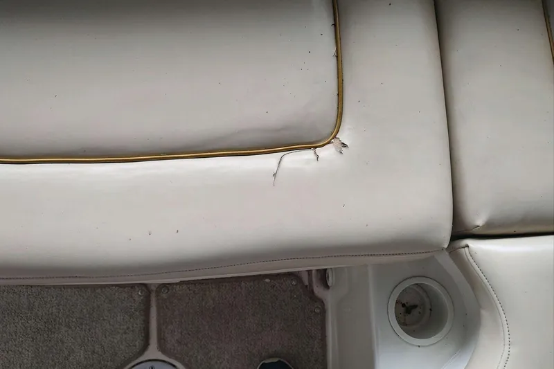 Slide: The Image of 2002 Sea Ray 270 Sundeck seat with visible upholstery damage and cup holder. - 8