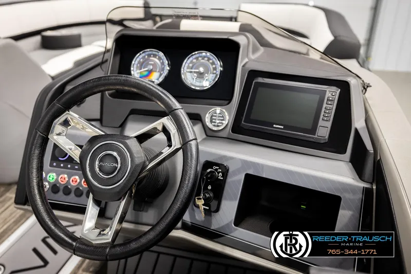 Slide: The Image of 2026 Avalon CAT QLS boat dashboard with steering wheel, gauges, and Garmin display. - 26