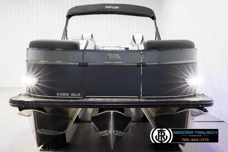 Slide: The Image of 2026 Avalon CAT QLS pontoon boat with sleek design and bright headlights in showroom. - 8