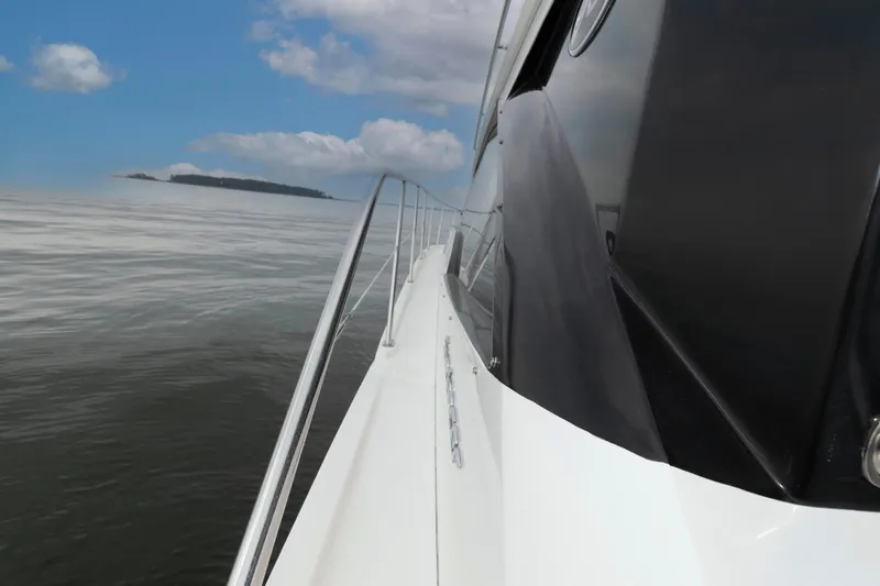 Slide: The Image of 2017 Sea Ray Sundancer 460 yacht cruising on calm waters under a blue sky. - 18