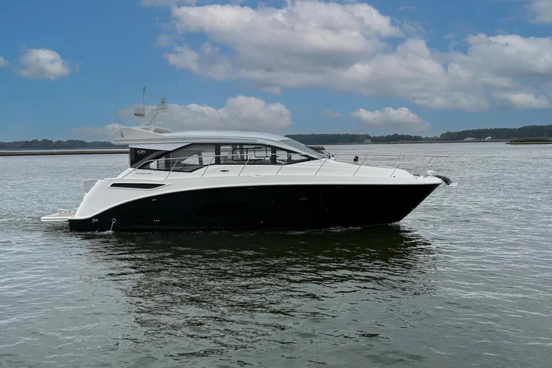 Slide: The Image of 2017 Sea Ray Sundancer 460 yacht cruising on calm waters under a partly cloudy sky. - 2