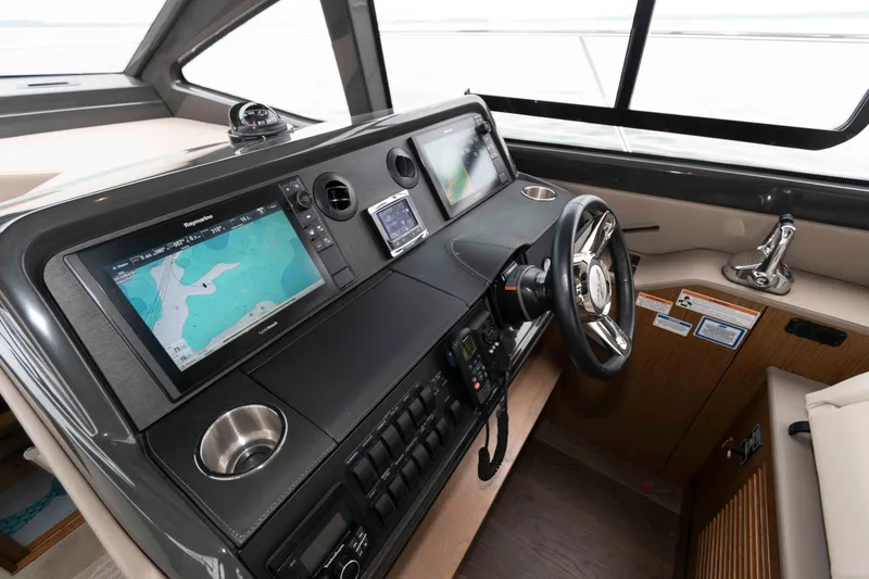 Slide: The Image of 2017 Sea Ray Sundancer 460 helm with advanced navigation displays and sleek steering wheel. - 29