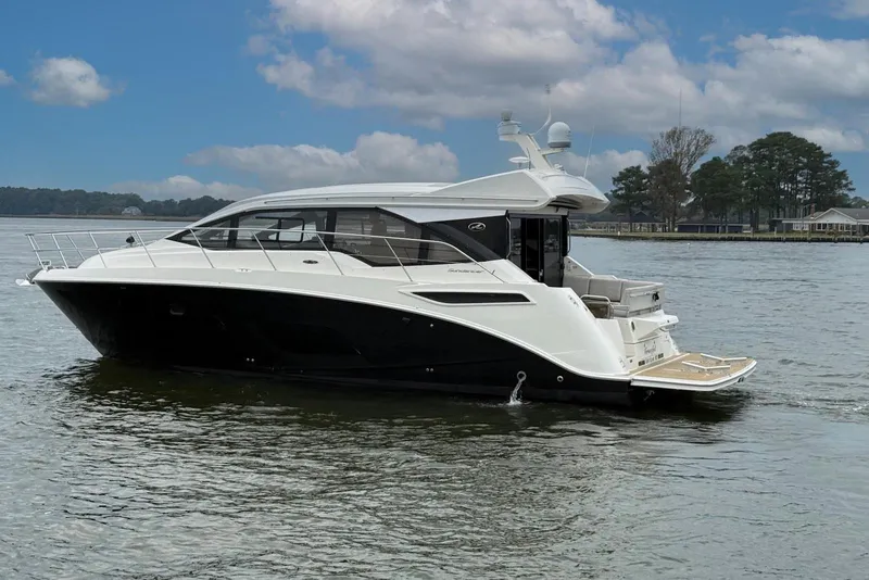Slide: The Image of 2017 Sea Ray Sundancer 460 yacht cruising on a calm lake under a partly cloudy sky. - 3