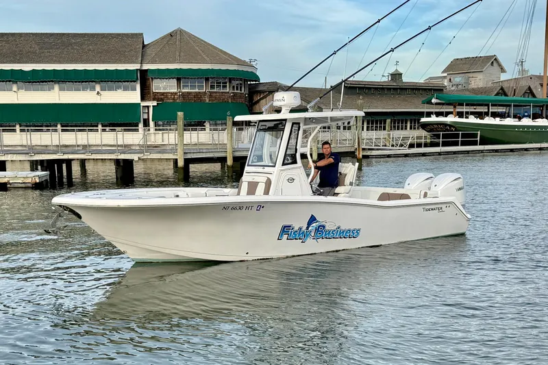 Slide: The Image of 2024 Tidewater 272 LXF boat named "Fishy Business" docked near a marina. - 10