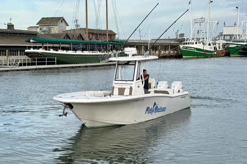 Slide: The Image of 2024 Tidewater 272 LXF boat cruising in a marina with fishing gear. - 12