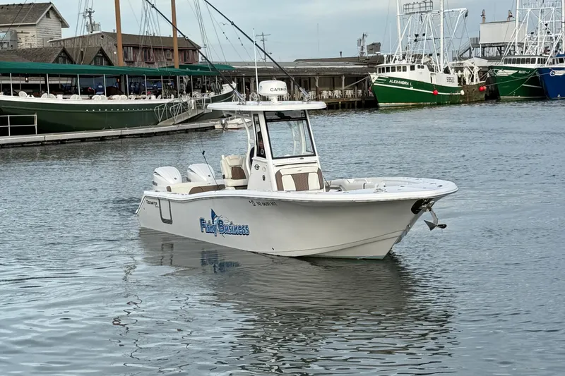 Slide: The Image of 2024 Tidewater 272 LXF boat on calm water near a marina. - 13